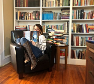 A.S. reading book in chair